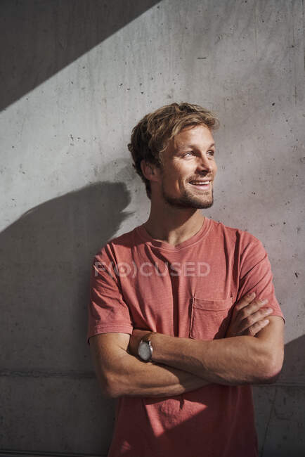 Portrait of man wearing red t-shirt at concrete wall — Stock Photo