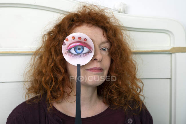 Portrait of redheaded woman with paper mask — Stock Photo