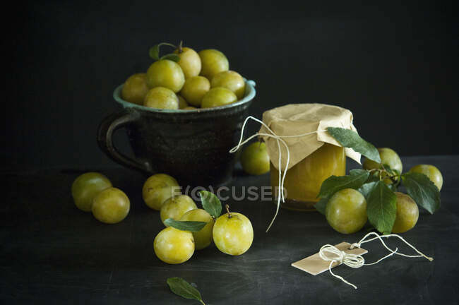 Studio shot of greengages and jar of homemade plum jam — Stock Photo