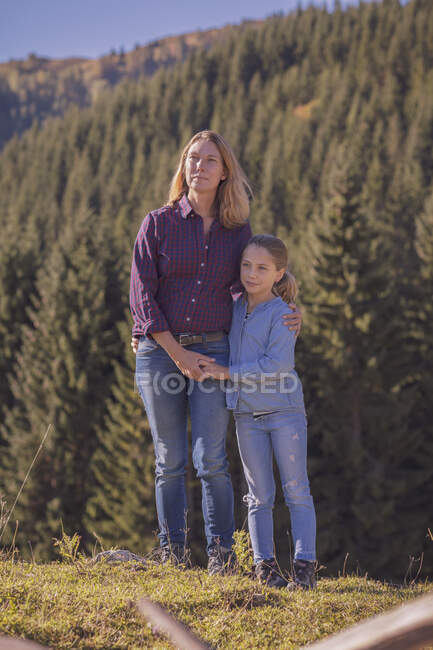 Мати з дочкою мандрують горами, обіймаючись. — стокове фото