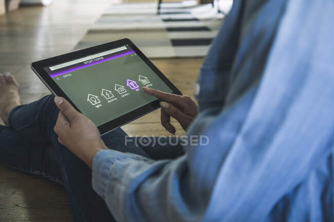 Jovem com tablet com funções inteligentes de controle de casa — Fotografia de Stock