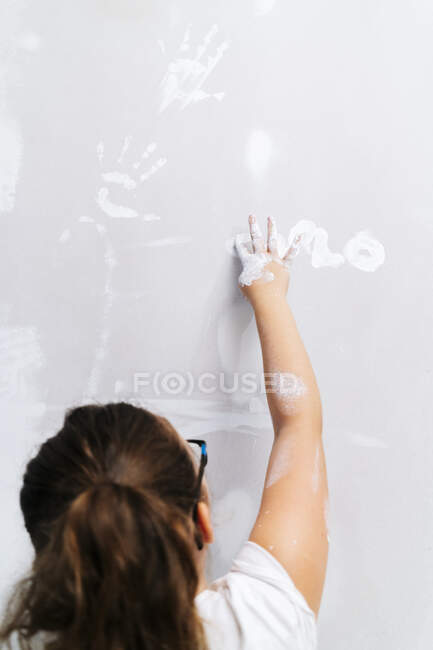 Дівчина малює пальцем на стіні — стокове фото