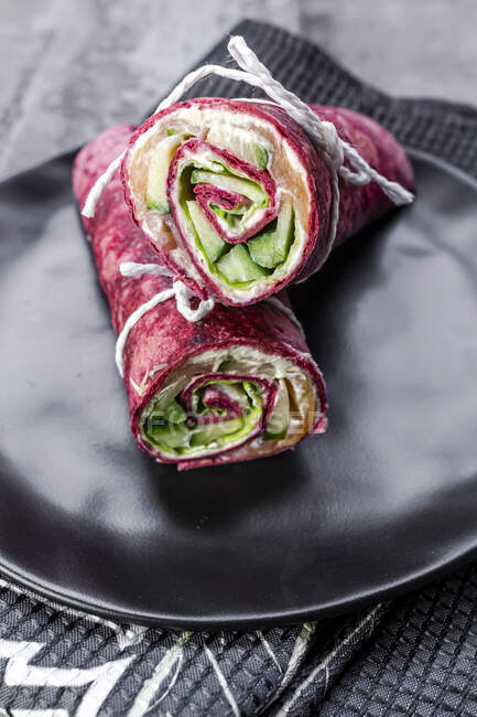 Beetroot wraps filled with ham, cheese, corn, iceberg lettuce, cucumbers and cream cheese — Stock Photo