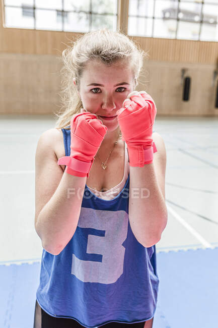 Portrait of confident female boxer in sports hall — Stock Photo