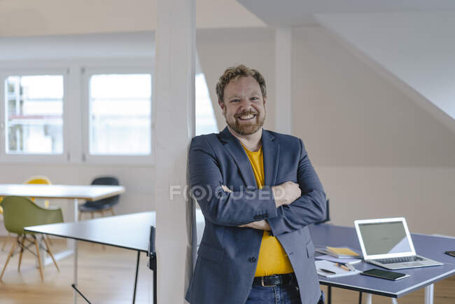 Портрет улыбающегося бизнесмена в офисе со столом для настольного тенниса — стоковое фото
