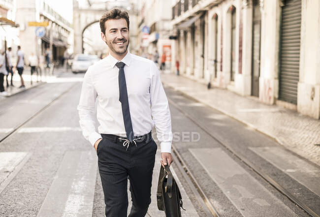 Smiling young businessman in the city on the go, Lisbon, Portugal — Stock Photo