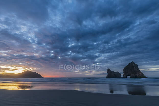 Nova Zelândia, Ilha do Sul, Tasman, Wharariki Beach e Archway Islands ao pôr do sol — Fotografia de Stock