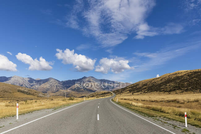 New Zealand, Clouds over empty State Highway 73 with mountains in background — Stock Photo