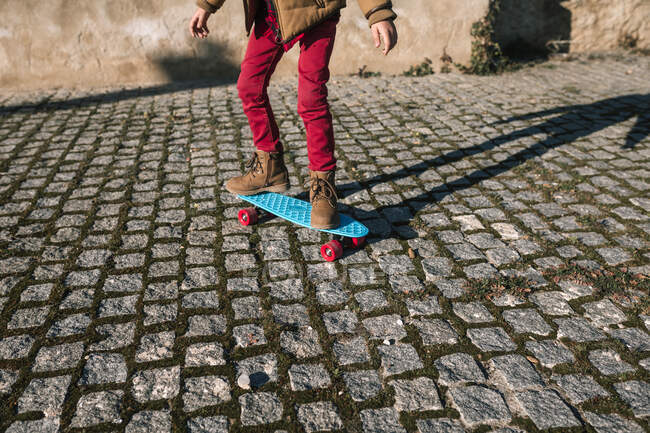 Low section of boy riding skateboard — Stock Photo
