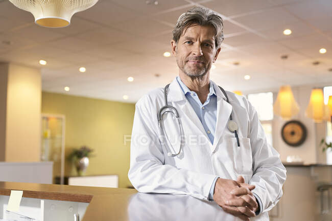 Retrato del médico confiado en la recepción en su práctica médica - foto de stock