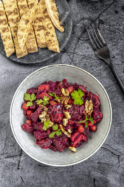 Pita bread and plate of beetroot salad with chick-peas, roasted walnuts and parsley — Stock Photo