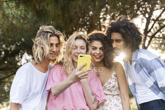 Gruppo di amici che utilizzano lo smartphone all'aperto — Foto stock
