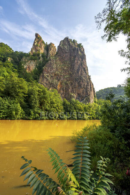 Germania, Renania-Palatinato, Bad Munster am Stein-Ebernburg, Fiume Nahe Giallo con formazione rocciosa di Rheingrafenstein sullo sfondo — Foto stock