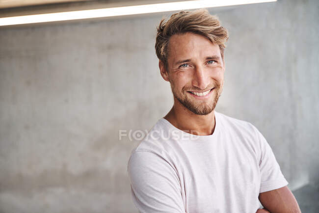 Portrait de jeune homme souriant portant un t-shirt blanc — Photo de stock