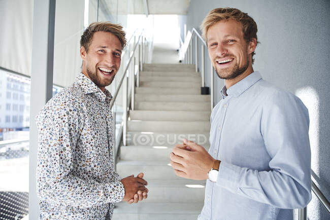 Porträt zweier glücklicher junger Geschäftsleute im Treppenhaus — Stockfoto
