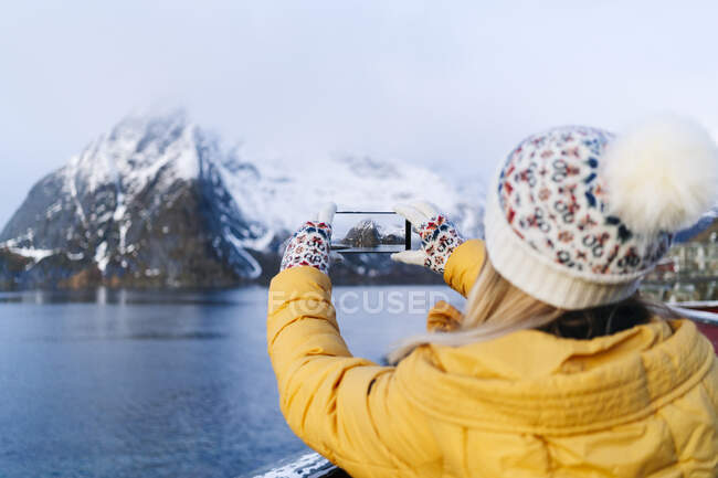 Turista tirar uma foto de smartphone em Hamnoy, Lofoten, Noruega — Fotografia de Stock