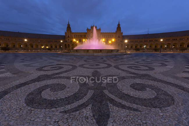 Spagna, Siviglia, Plaza de Espana, Fontana ed edifici illuminati al tramonto — Foto stock