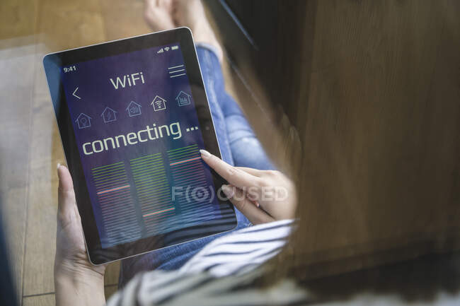 Jovem com tablet com funções inteligentes de controle de casa — Fotografia de Stock