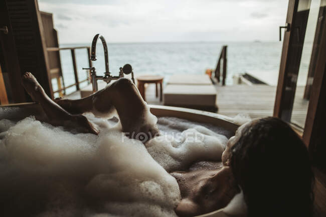 Женщина отдыхает в ванне с видом на море, остров Магудхуваа, атолл Гаафу Дхаалу, Мальдивы — стоковое фото