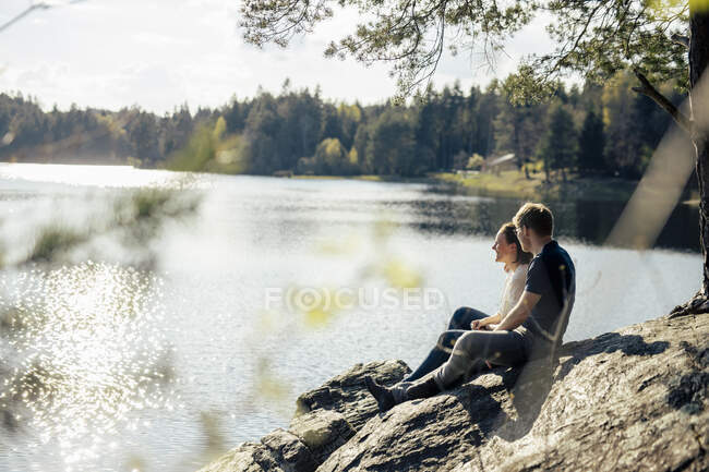 Couple affectueux assis au bord du lac, Forstsee, Carinthie, Autriche — Photo de stock