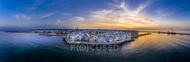 Italy, Apulia, Monopoli, Aerial view of sea and old town at sunset — Stock Photo