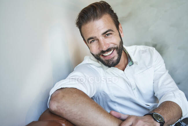 Portrait d'homme d'affaires heureux assis sur le canapé portant une chemise blanche — Photo de stock