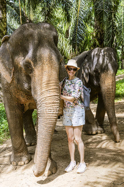Porträt einer lächelnden Frau mit Elefanten im Heiligtum, Krabi, Thailand — Stockfoto