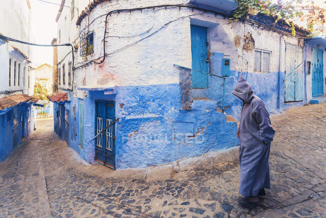 Man walking in the old city of Chefchaouen with the famous blue buildings, Chefchaouen, Marocco — Foto stock