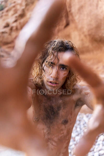 Jovem coberto de lama em uma praia — Fotografia de Stock
