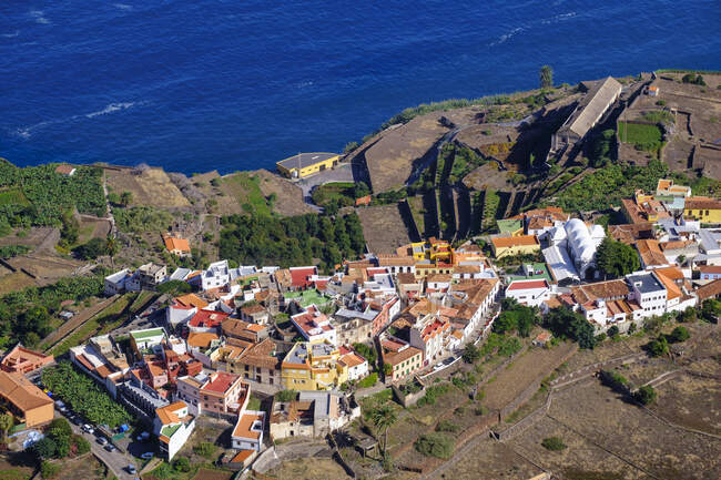 Spain, Canary Islands, Agulo, Aerial view of town lying at edge of coastal cliff — Stock Photo