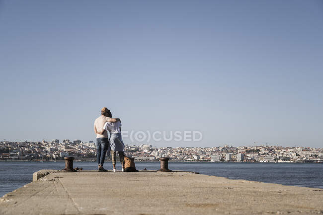 Junges Paar auf einem Steg am Wasser, Lissabon, Portugal — Stockfoto
