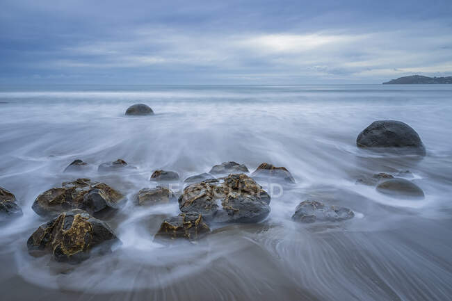 Nuova Zelanda, Oceania, Isola del Sud, Southland, Hampden, Otago, Moeraki, Koekohe Beach, Moeraki Boulders Beach, Moeraki Boulders, Round stones on beach at disk — Foto stock