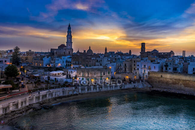 Italia, Apulia, Monopoli, Vista aérea del mar y el casco antiguo al atardecer - foto de stock
