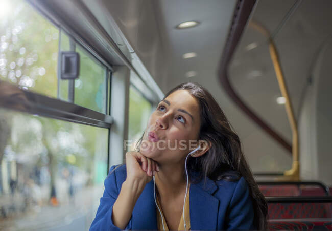 Jovem mulher ouvindo música em um ônibus com fones de ouvido — Fotografia de Stock