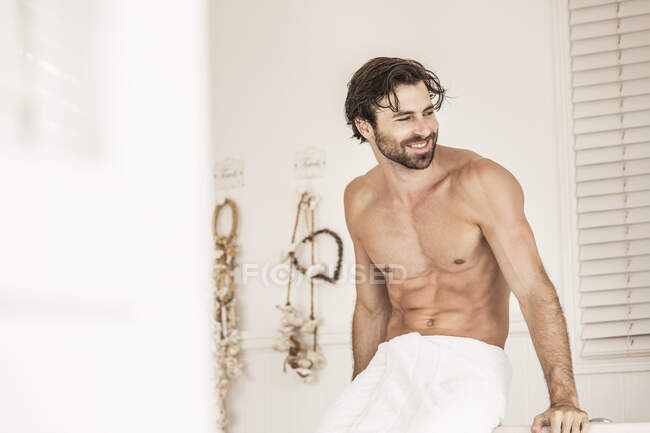 Shirtless young man in a badroom — Stock Photo