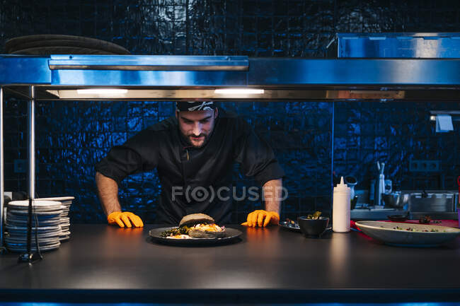 Chef regardant plat préparé dans la cuisine du restaurant — Photo de stock