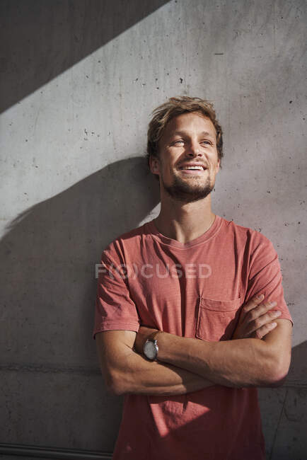 Retrato del hombre con camiseta roja en la pared de hormigón - foto de stock