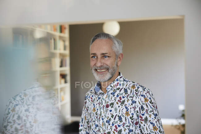 Ritratto di uomo maturo sorridente che indossa camicia fantasia a casa — Foto stock