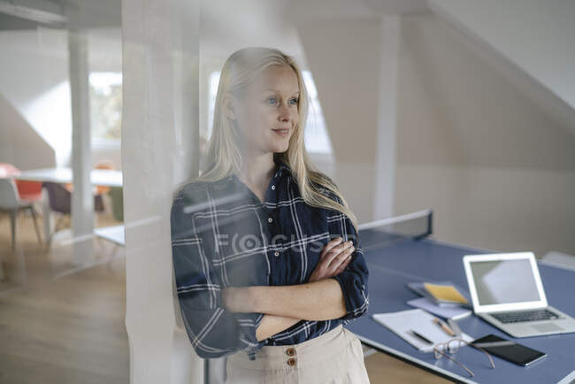 Портрет молодой предпринимательницы в офисе со столом для настольного тенниса — стоковое фото