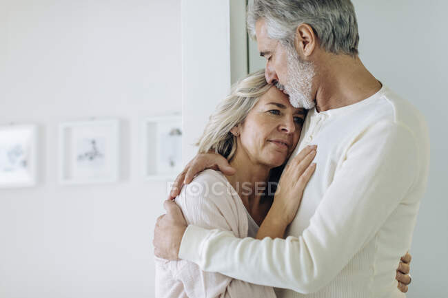 Сердечна зріла пара обнімається вдома — стокове фото