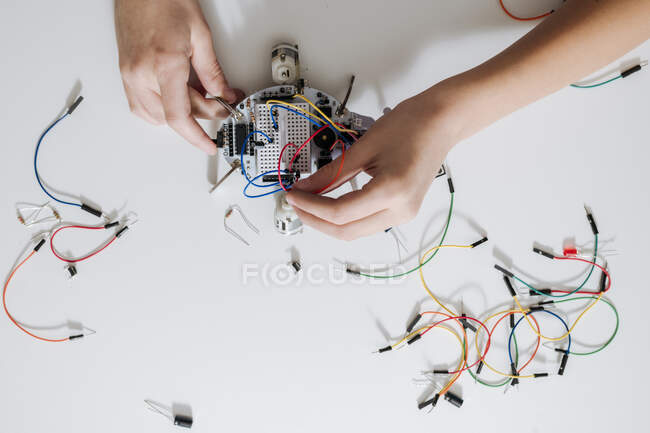 Boy assembling robot on a table, from above — Stock Photo