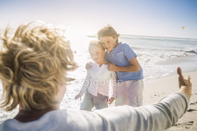 Батько бавився зі своїми синами на пляжі. — стокове фото