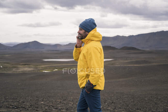 Uomo maturo che parla sul suo smartphone negli altopiani islandesi — Foto stock