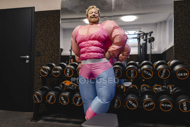 Fier homme portant un costume rose bodybuilder dans la salle de gym — Photo de stock