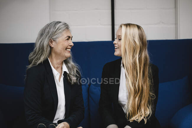 Felice maturo e giovane donna d'affari parlando sul divano — Foto stock