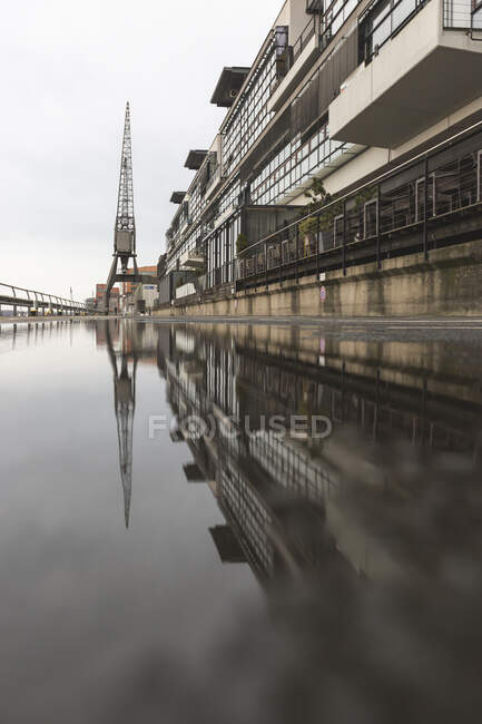 Alemanha, Hamburgo, construção portuária refletindo em poça de água — Fotografia de Stock