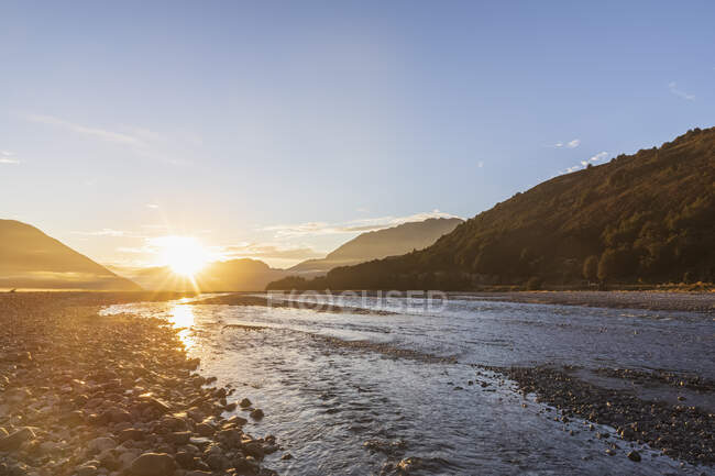 Nouvelle-Zélande, district Grey, Inchbonnie, lever du soleil sur la rivière Waimakariri dans le parc national du col Arthurs — Photo de stock