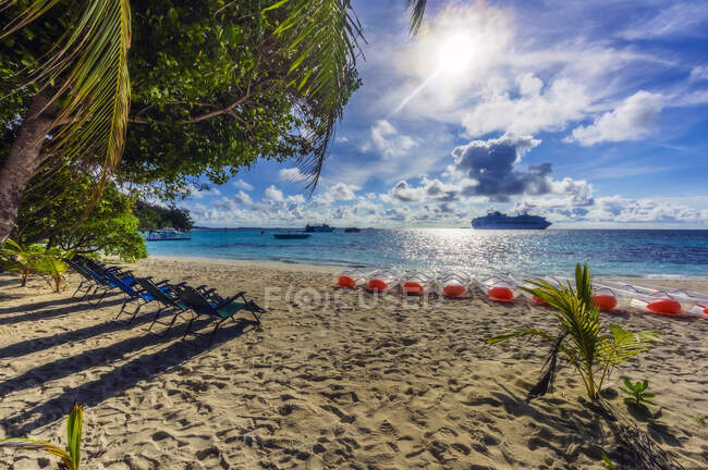 Papua Nuova Guinea, Provincia della Baia di Milne, Righe di sedie a sdraio e barche a remi sulla spiaggia sabbiosa costiera in estate — Foto stock