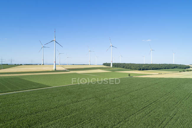 Германия, Бавария, беспилотник вид зеленых сельских полей летом с ветроэлектростанцией на заднем плане — стоковое фото