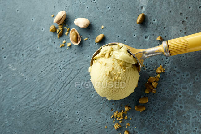 Pistachio ice cream on scoop and nuts — Stock Photo